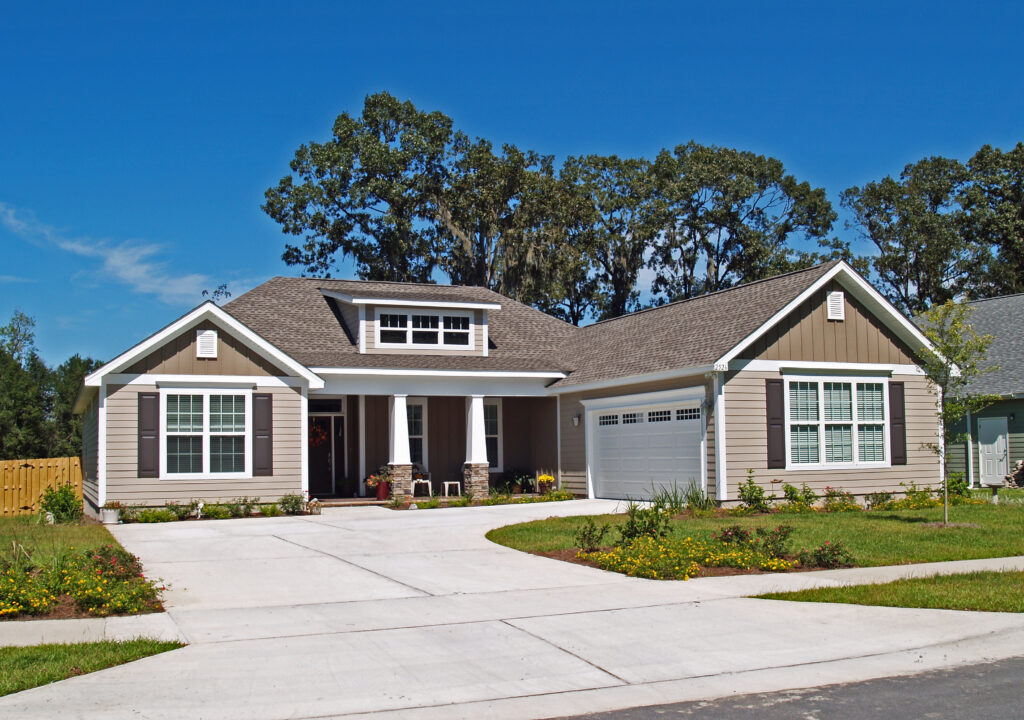 Single story home with garage, tan siding, and brown roofing in Coeur d'Alene , Idaho.