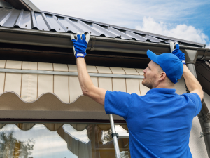Professional roofer in Spokane inspecting gutter system