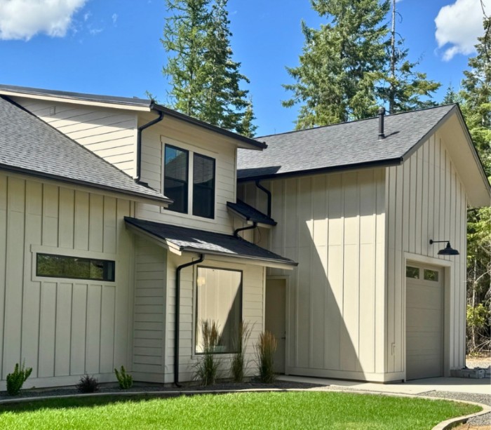 Mid-class home with brand new dark blue-ish gray siding installed by Lake City Roofing
