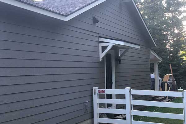 Close up of the outside of a home with new dark blue-ish gray siding installed by {BuisnessName}