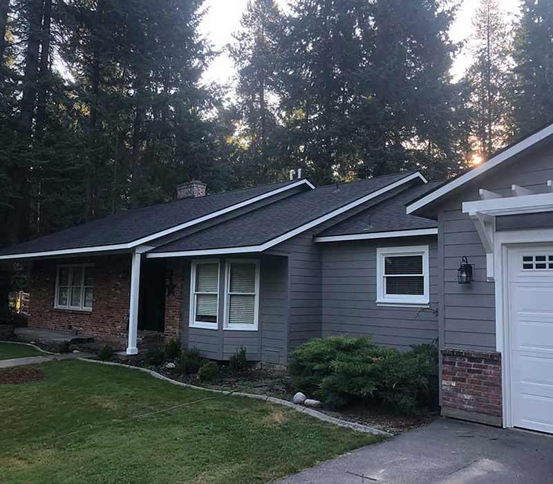 Mid-class home with brand new dark blue-ish gray siding installed by Lake City Roofing